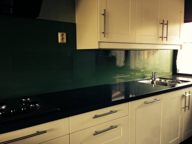 Groene glazen achterwand in de keuken