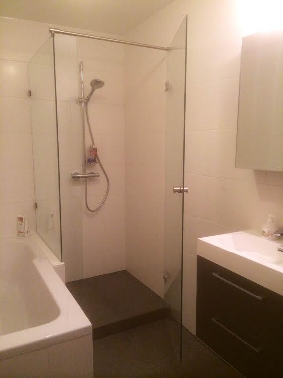 Glas douchedeur met zijpaneel naast het bad
