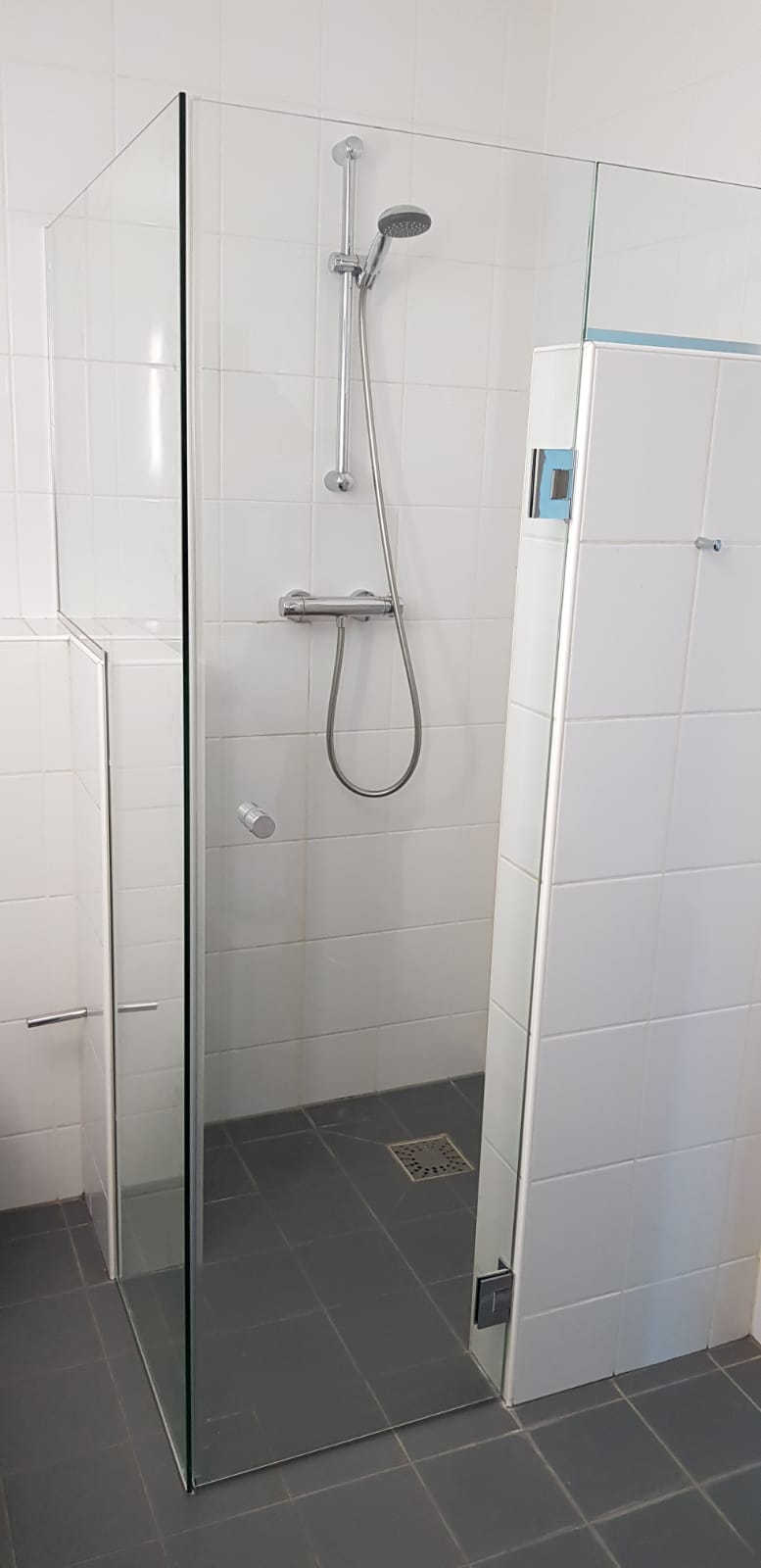 Smalle douchedeur tegen muurtje